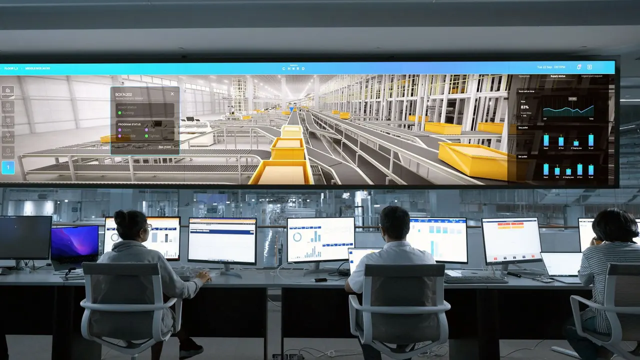 Bir fabrikanın kontrol odasında operatör masalarının üstündeki geniş ekran duvarında dijital bilgi ekranı